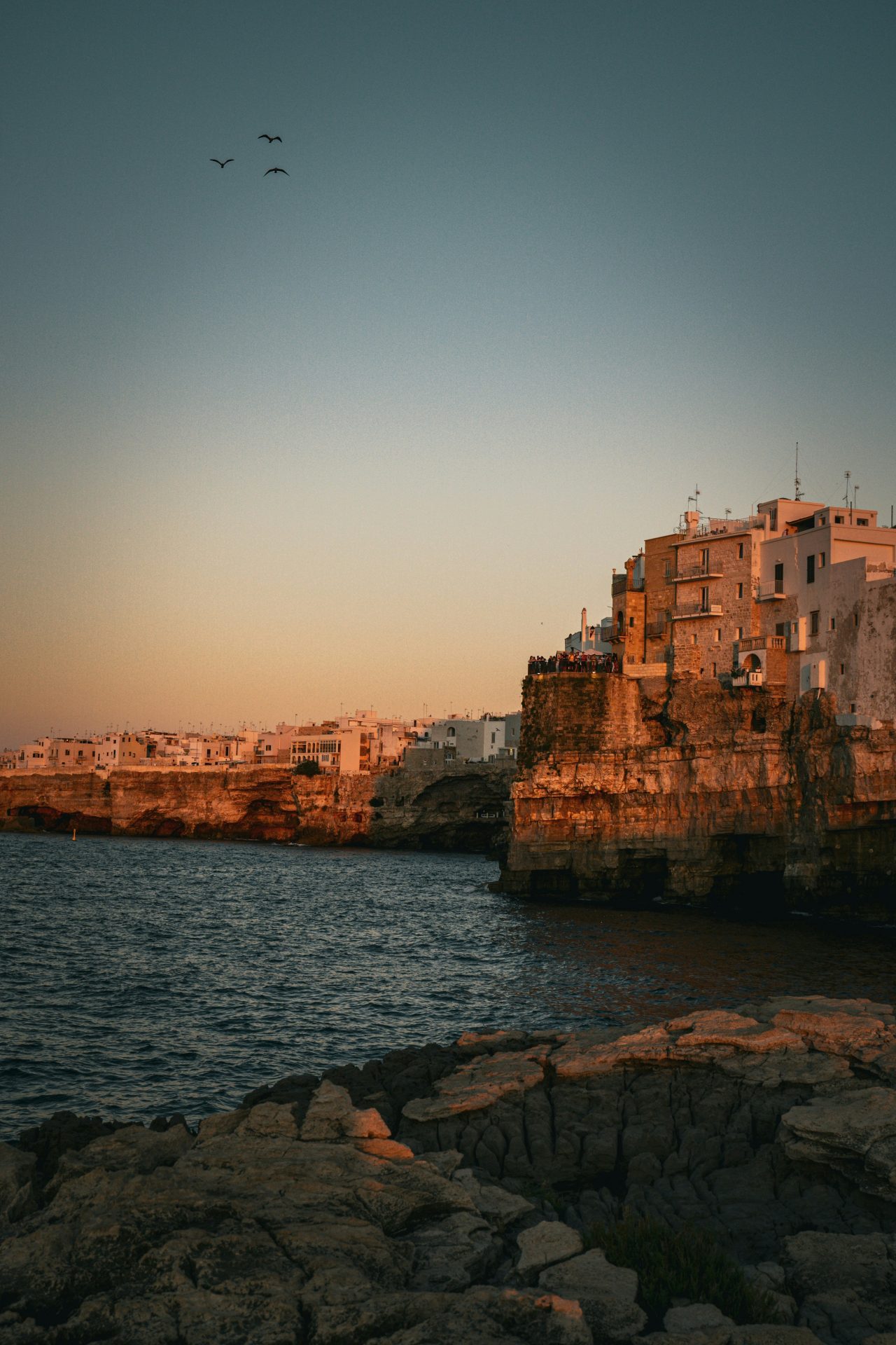 Coppia che brinda durante un'esperienza romantica in barca al tramonto lungo la costa della Puglia
